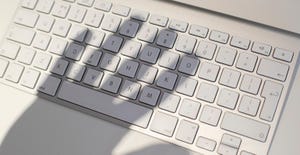 shadow of a hand on top of a keyboard