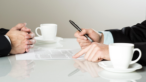businessmen signing contracts at a table