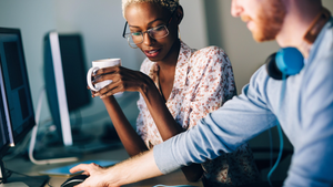 two workers collaborating on computers